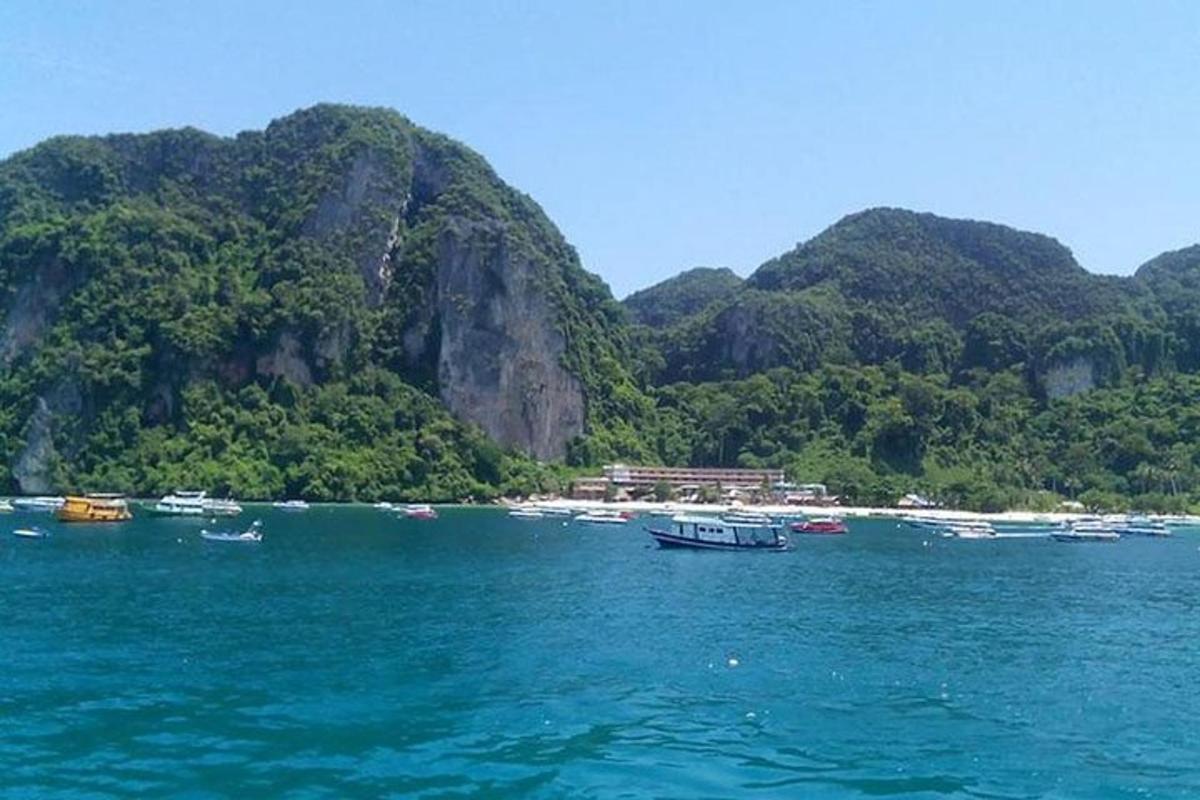 a group of boats in the water near a mountain
