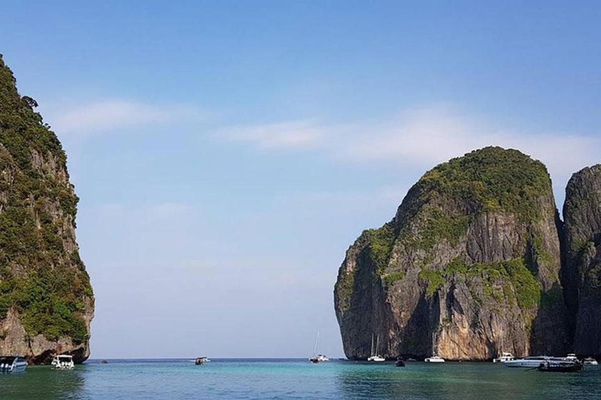 a group of boats in the water near some cliffs
