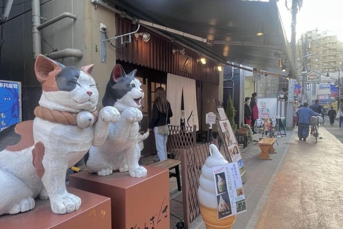 due statue di gatti seduti su scatole in una strada