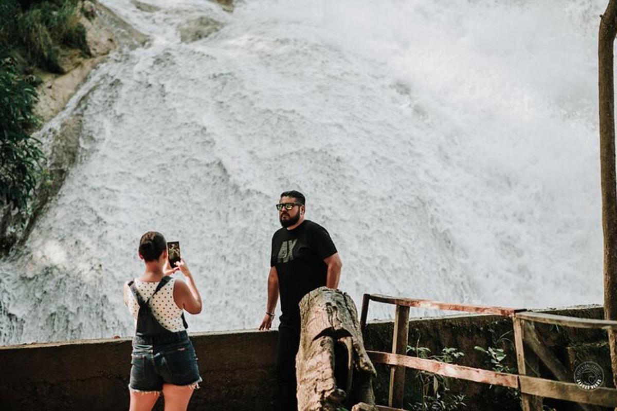 Un hombre y una mujer tomando una fotografía de una cascada.