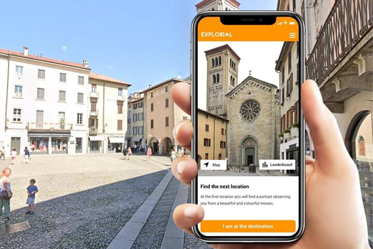 cilvēks, kurš tur rokās mobilo tālruni, lai nofotografētu baznīcu
