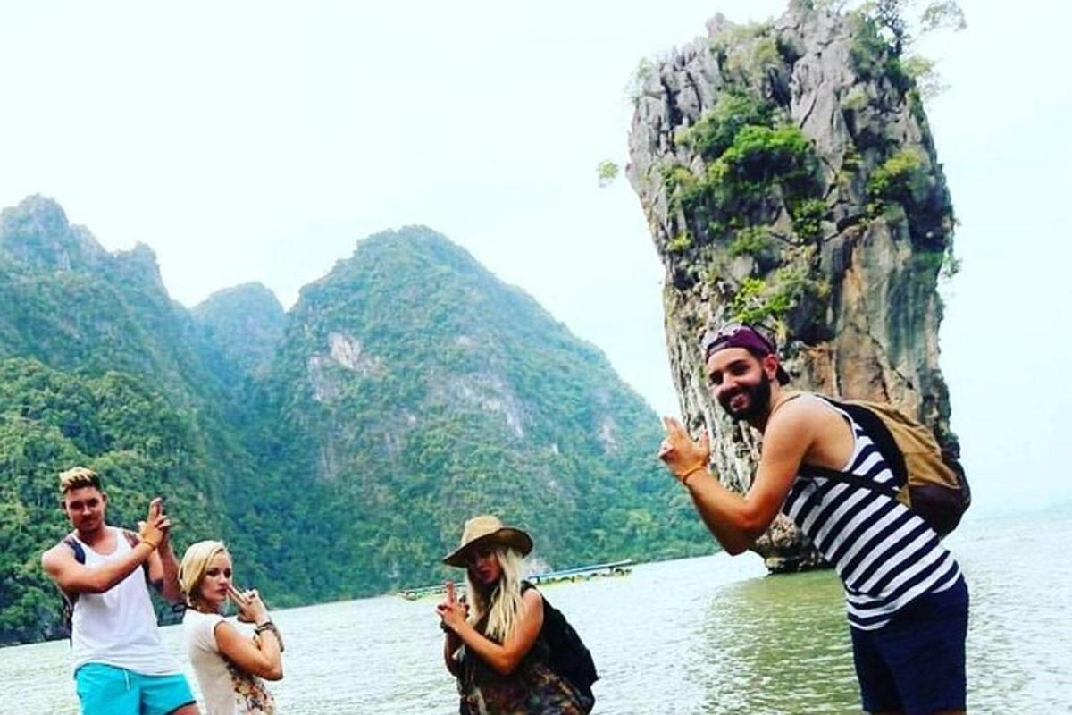 sekumpulan orang berdiri di dalam air berhampiran gunung