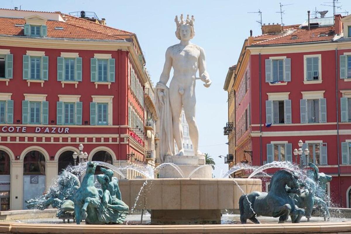 une statue dans une fontaine devant deux bâtiments