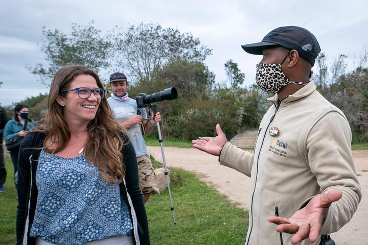 a woman standing next to a man wearing a mask