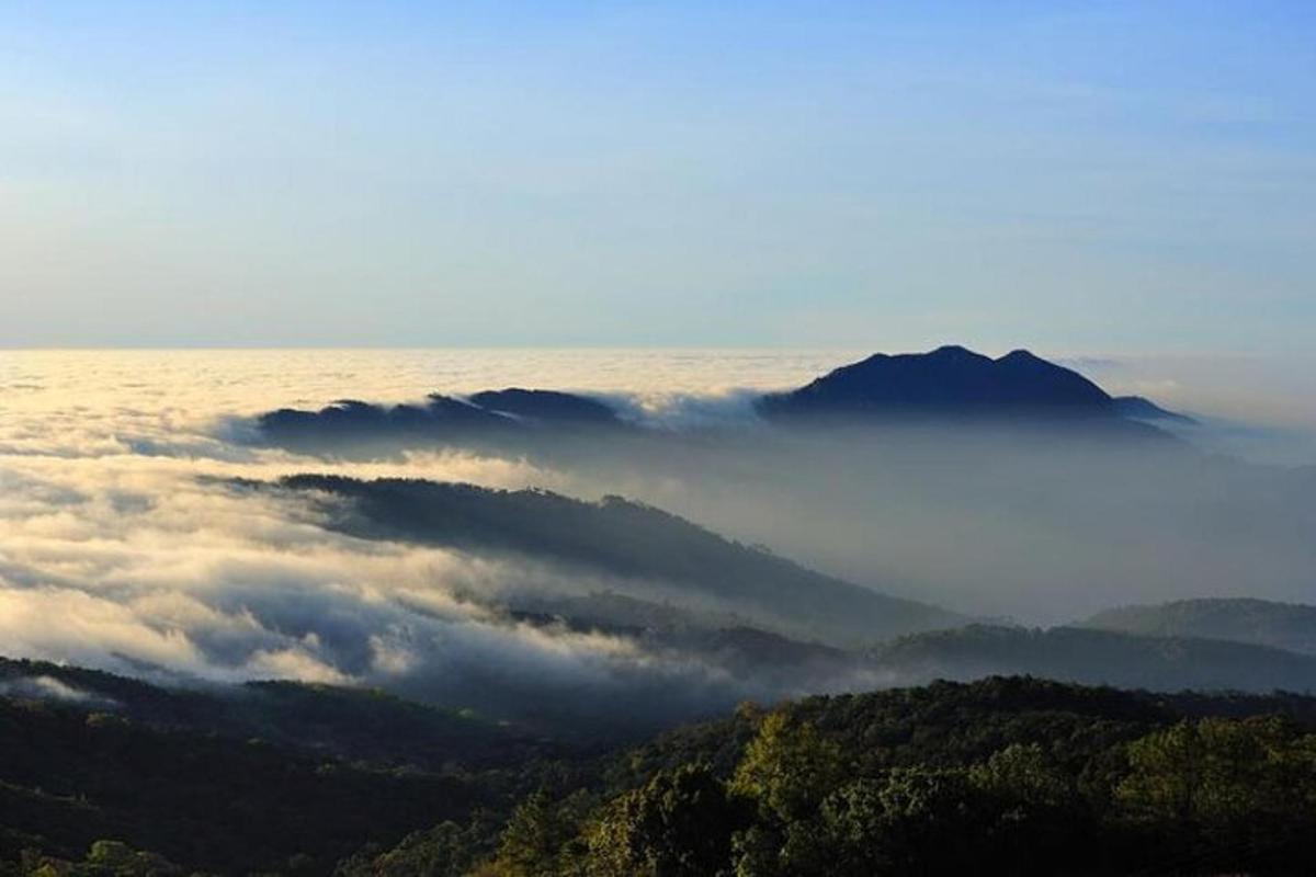 a view of a foggy valley with mountains in the background