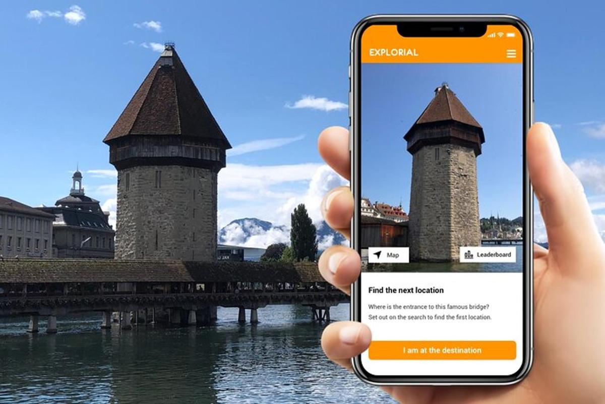 eine Person, die vor einer Brücke ein Mobiltelefon hochhält