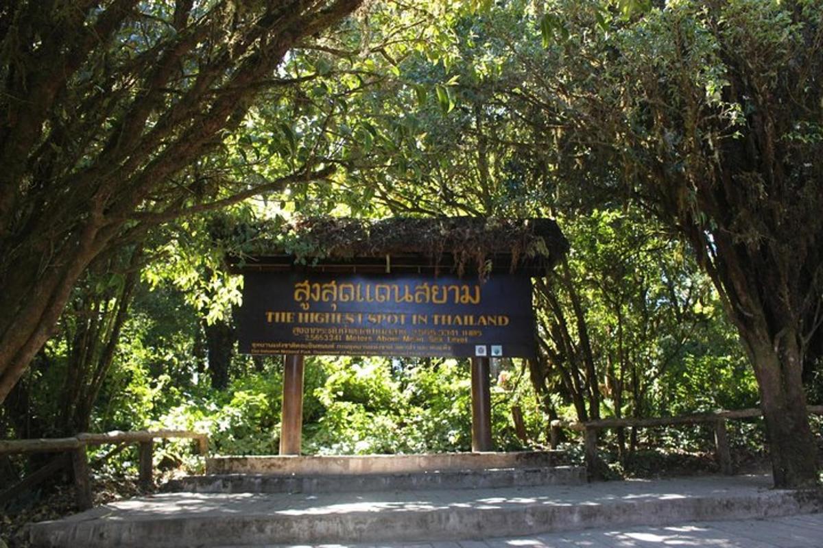 uma placa no meio de um parque com árvores