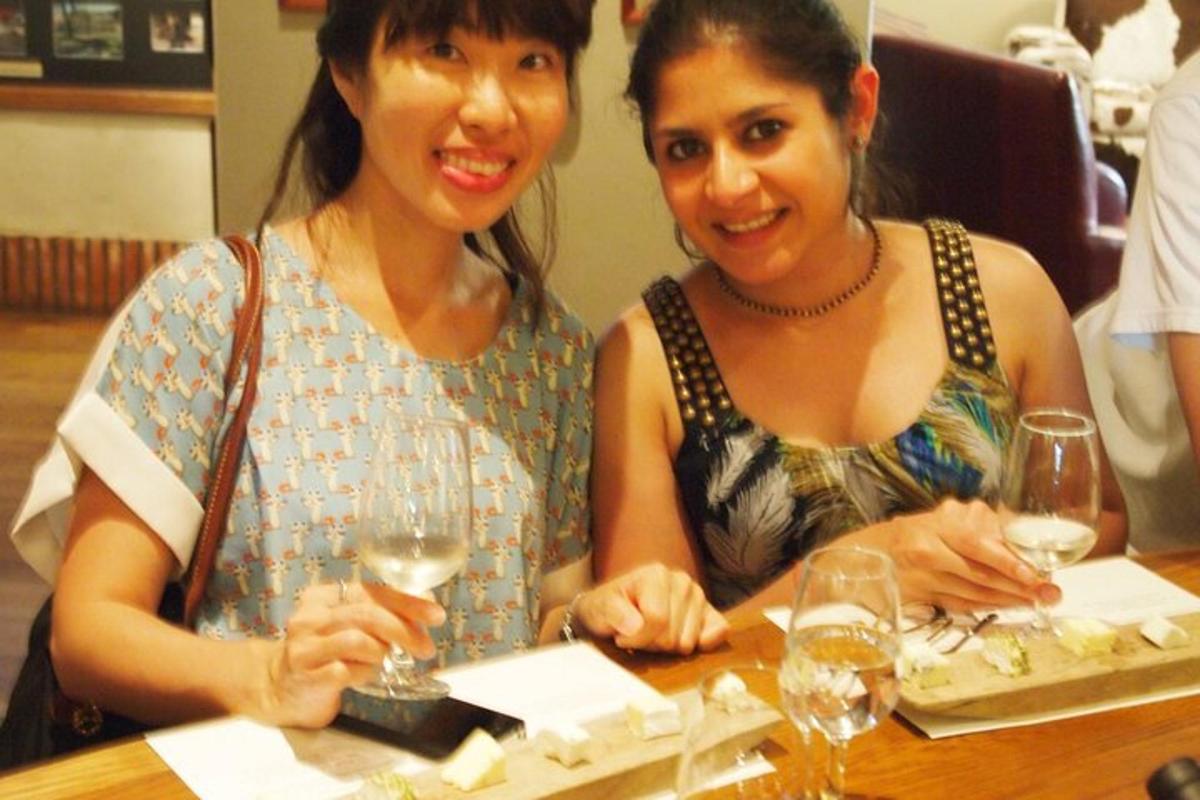 two women sitting at a table with wine glasses