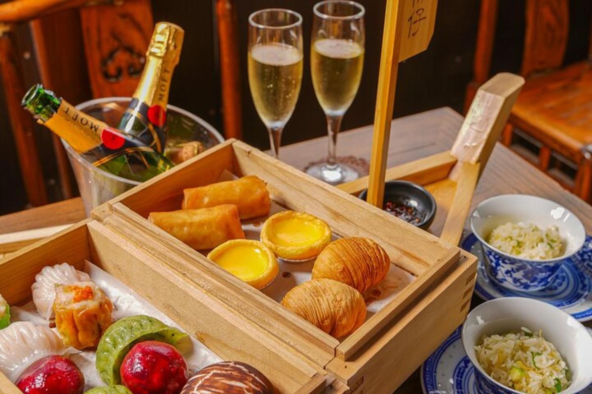 một cái bàn có một hộp thức ăn và hai ly sâm panh