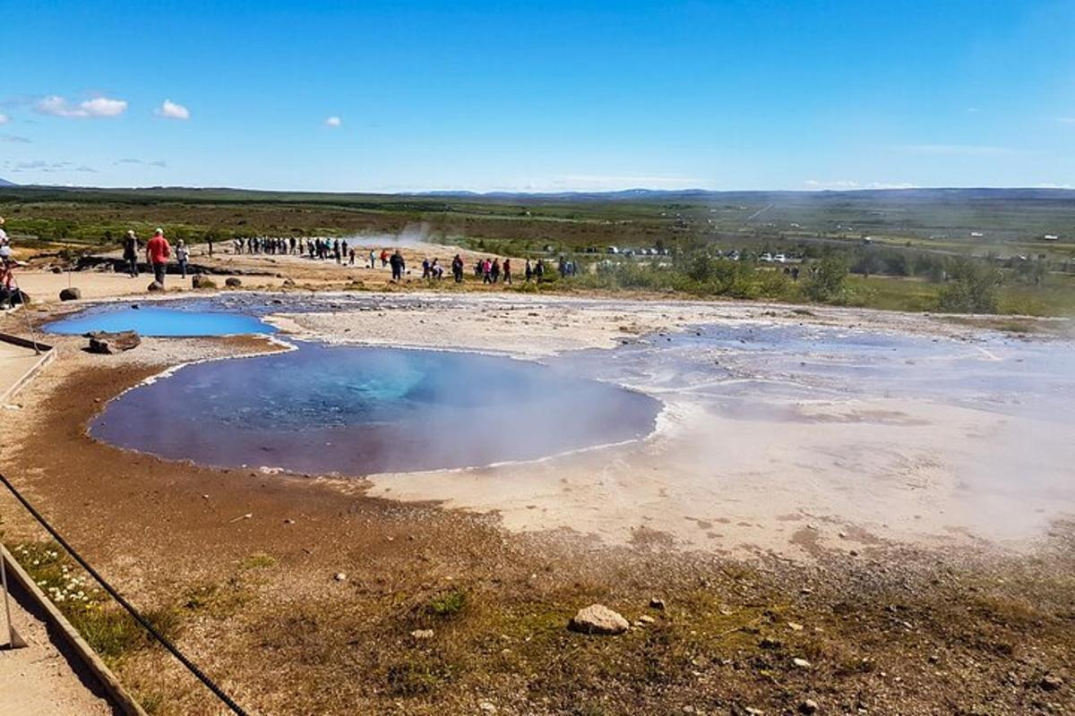 ryhmä ihmisiä seisomassa vesilammikon ympärillä