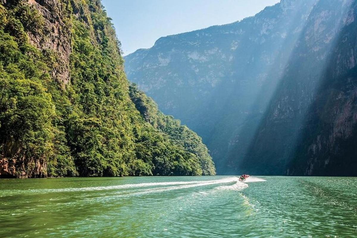 a boat on a river in front of mountains