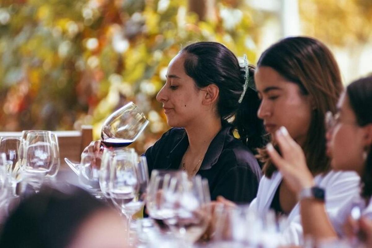 Dos mujeres sentadas en una mesa con copas de vino