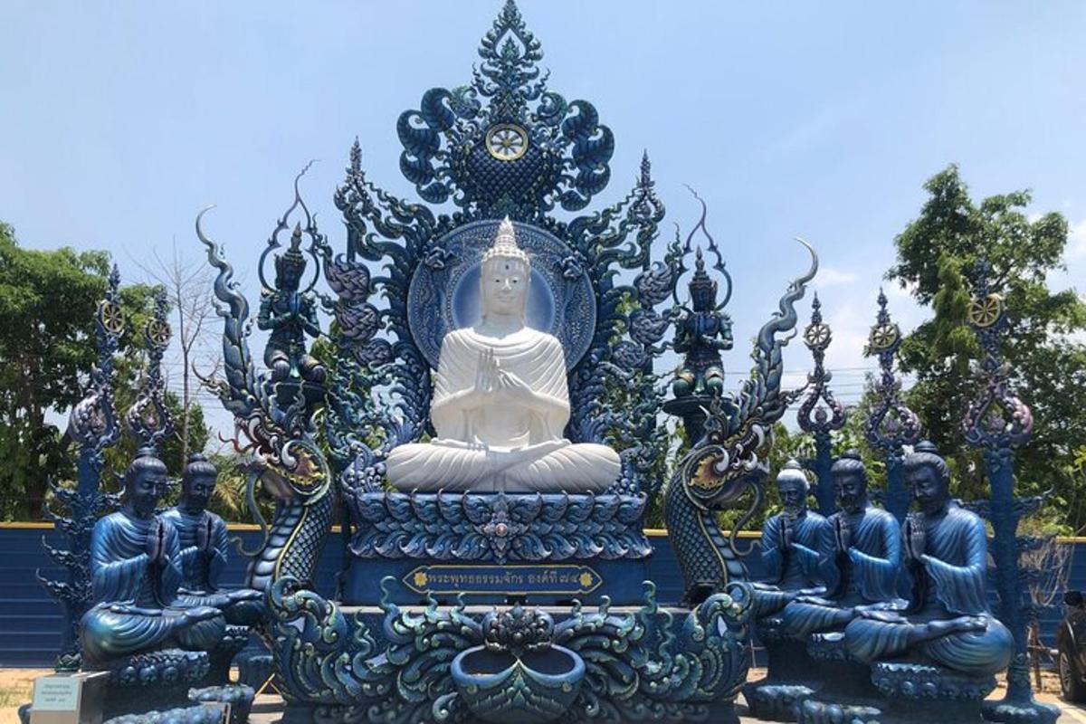 una grande statua di un Buddha seduto in mezzo alla folla
