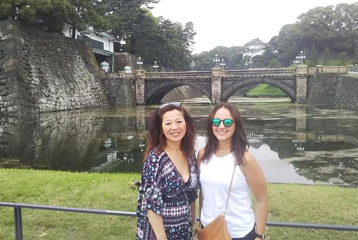 Dos mujeres están paradas frente a un puente.