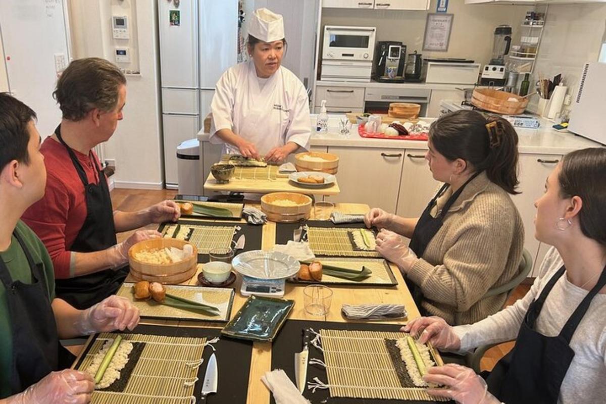 un grup de persones dretes al voltant d'una taula a la cuina