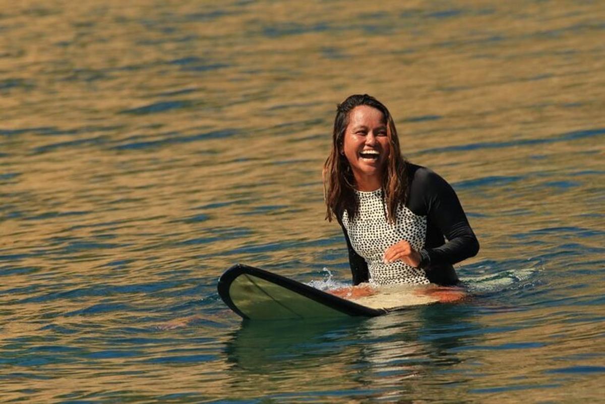 uma mulher sentada em uma prancha de surfe na água