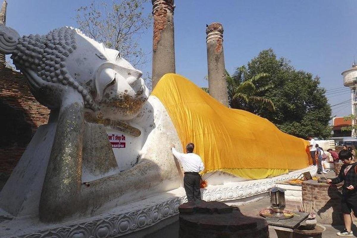 ein Mann steht neben einer Löwenstatue