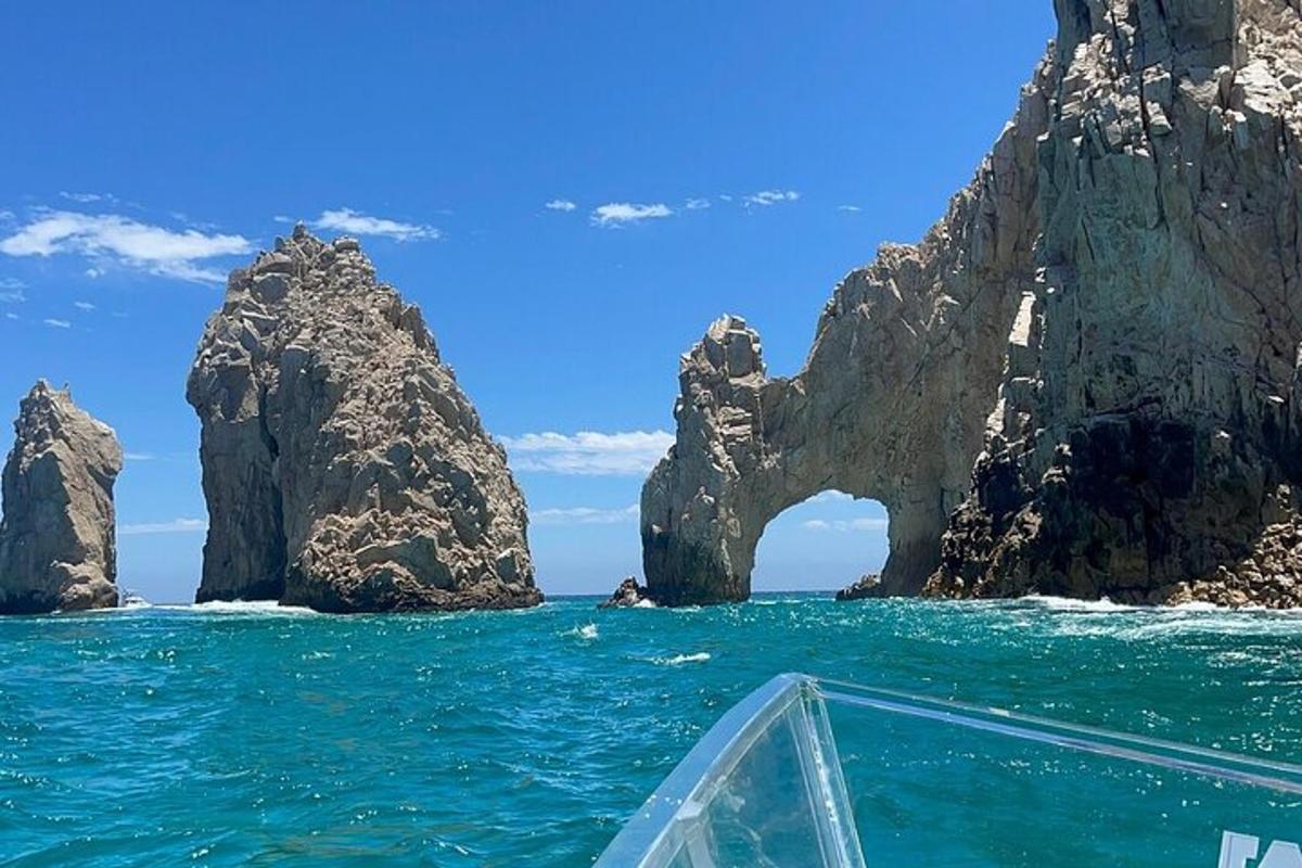 una barca nell'oceano con un arco di roccia nell'acqua