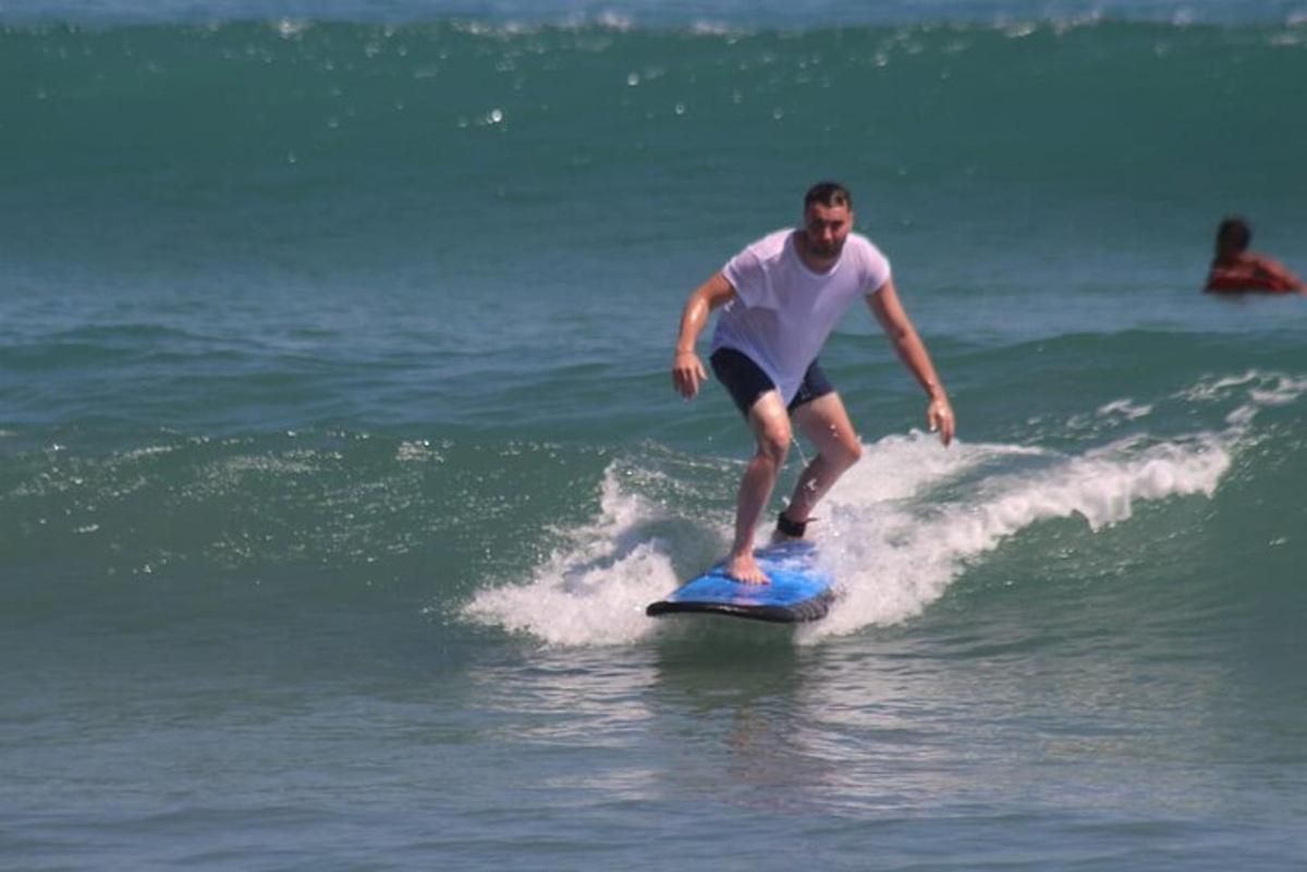 moški, ki jaha val na deski za surfanje v oceanu