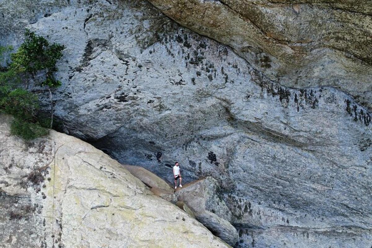 un home dret al vessant d'una muntanya rocosa