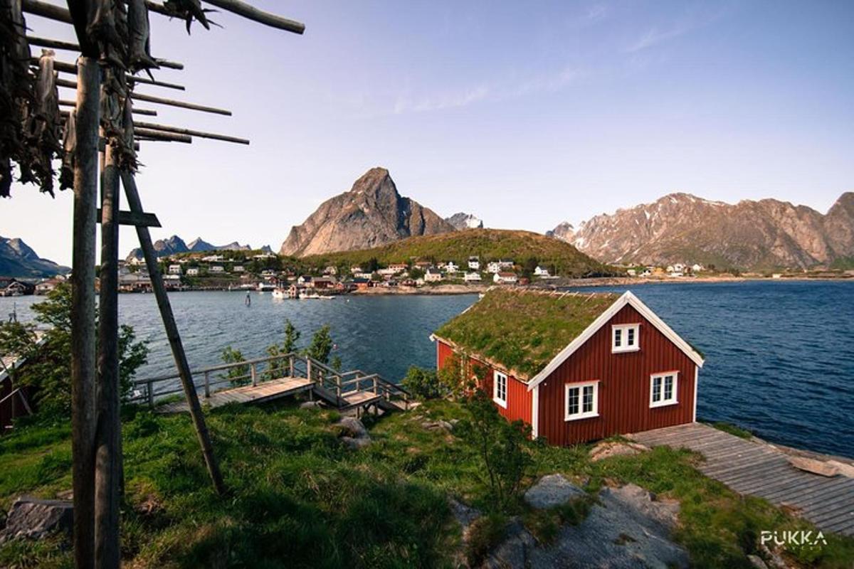 a red house on the shore of a body of water