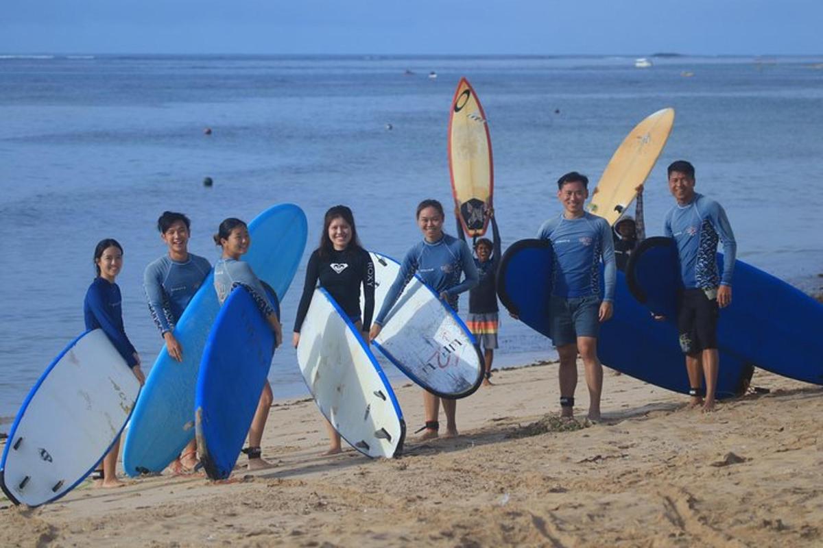 a group of people standing on the beach holding surfboards