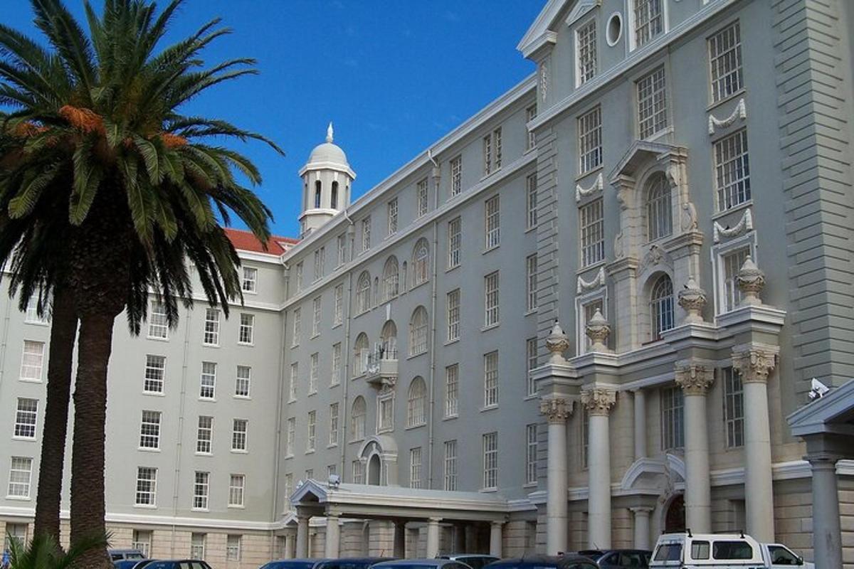 a large white building with a palm tree in front of it