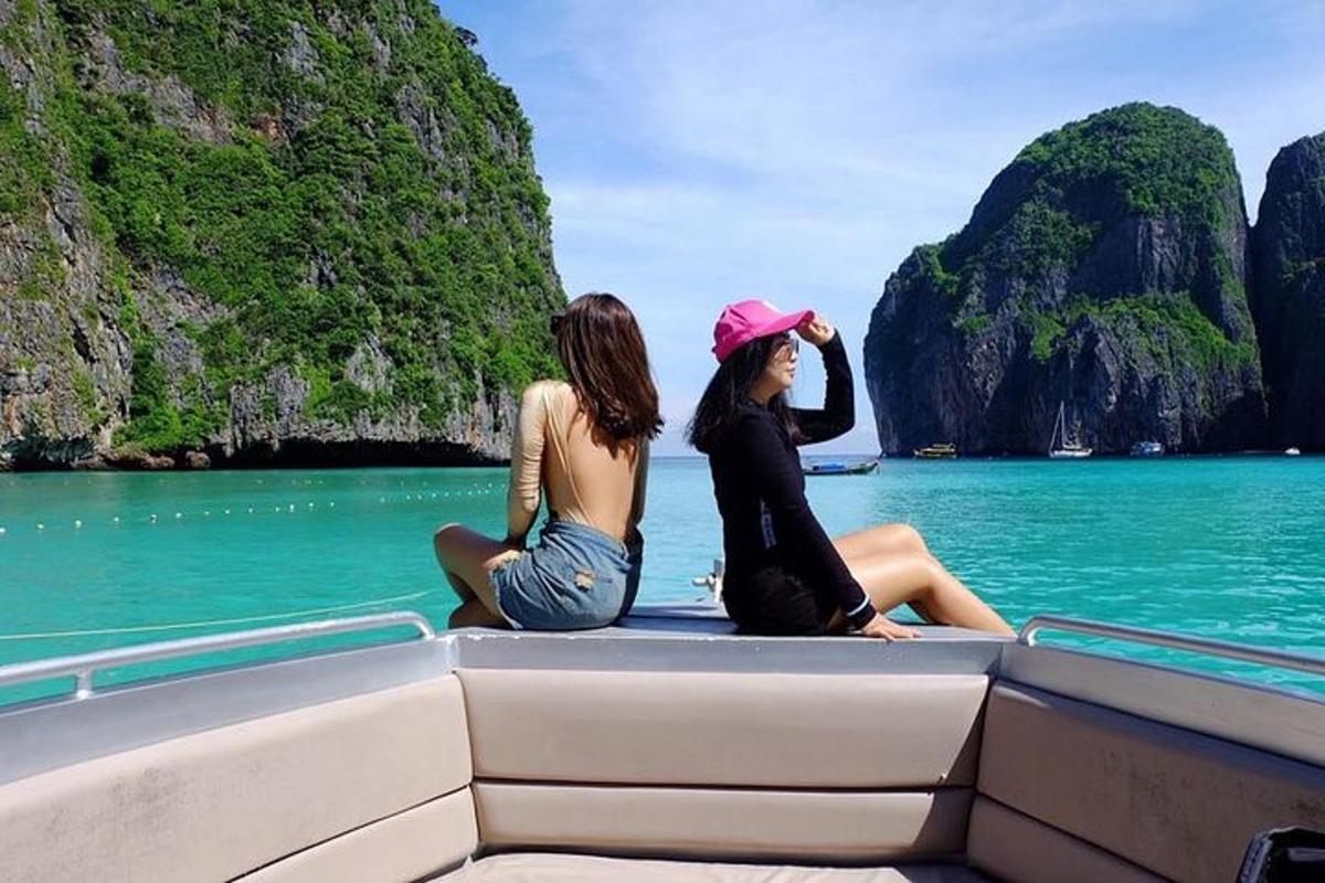 two women sitting on the back of a boat in the ocean
