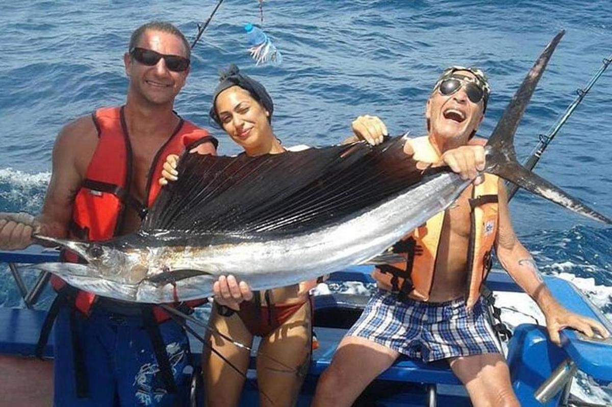 Τρεις άντρες σε μια βάρκα κρατώντας ένα μεγάλο ψάρι