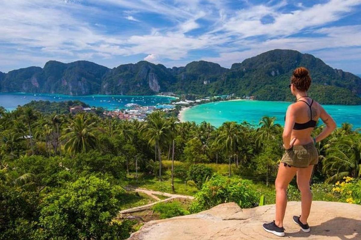 a woman standing on a rock looking at the ocean