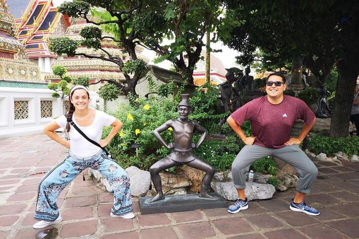 ein Mann und eine Frau sitzen neben einer Statue