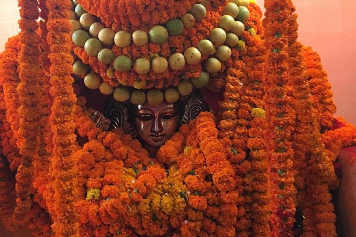 a wall covered in a bunch of flowers with a statue
