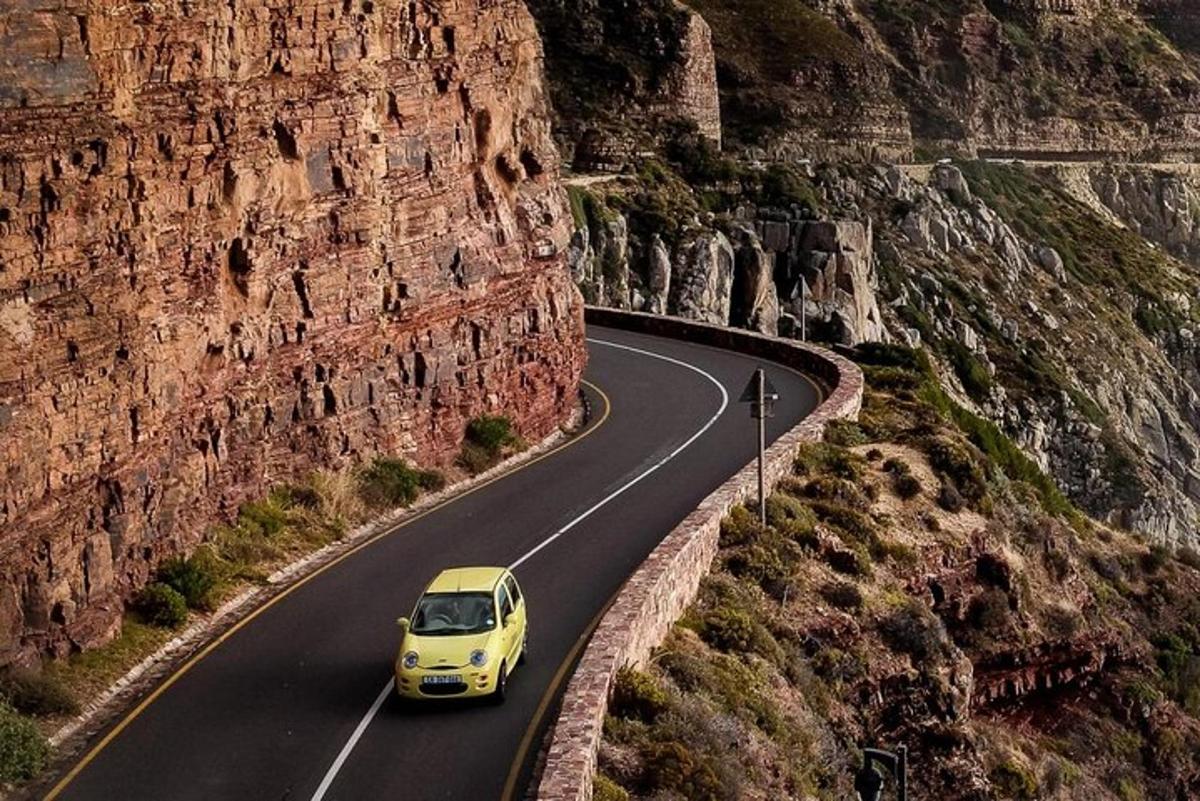 um carro amarelo descendo uma estrada sinuosa na montanha