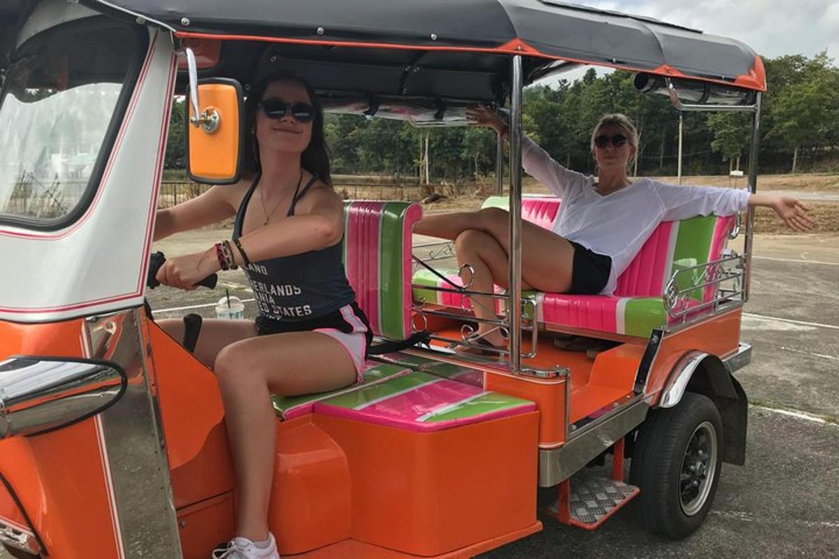 Un hombre y una mujer viajando en un carrito de golf
