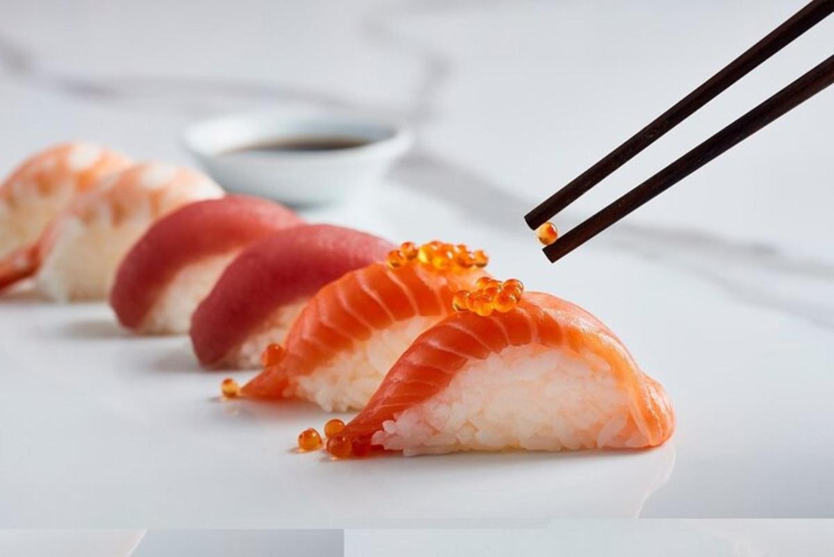 a plate topped with sushi with chopsticks