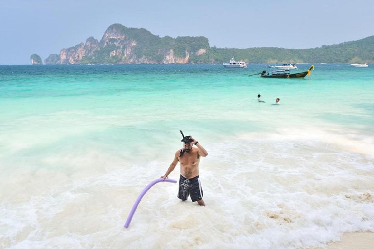 moški stoji na plaži s frizbijem