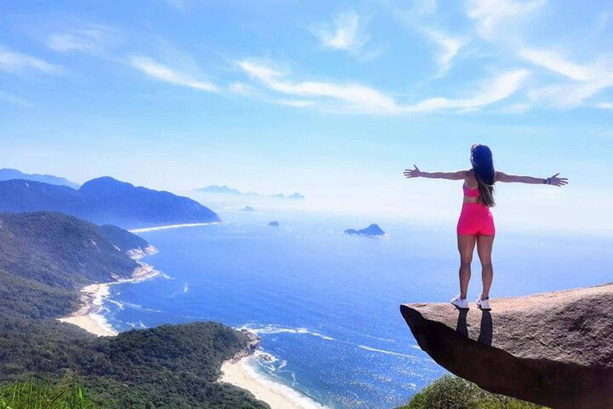 a woman standing on top of a cliff overlooking the ocean