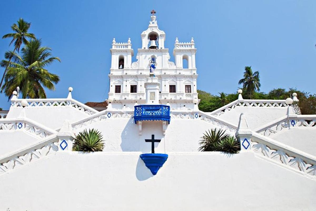 Una iglesia blanca con una cruz delante de ella