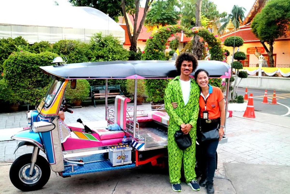 Un hombre y una mujer de pie junto a un carrito de golf.