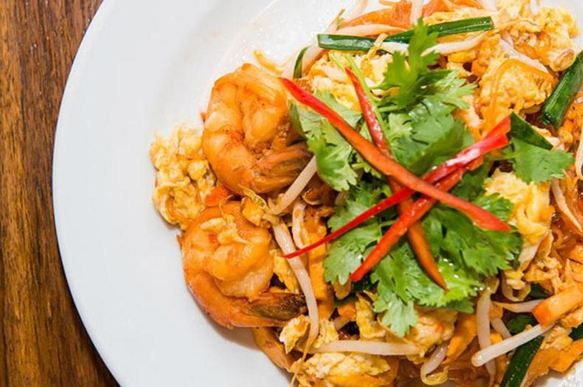 Un plato blanco de comida con camarones y arroz.
