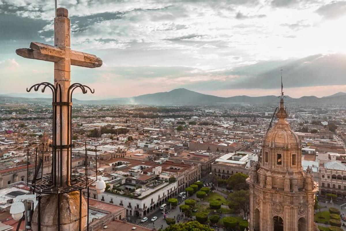 a cross on top of a building with a city