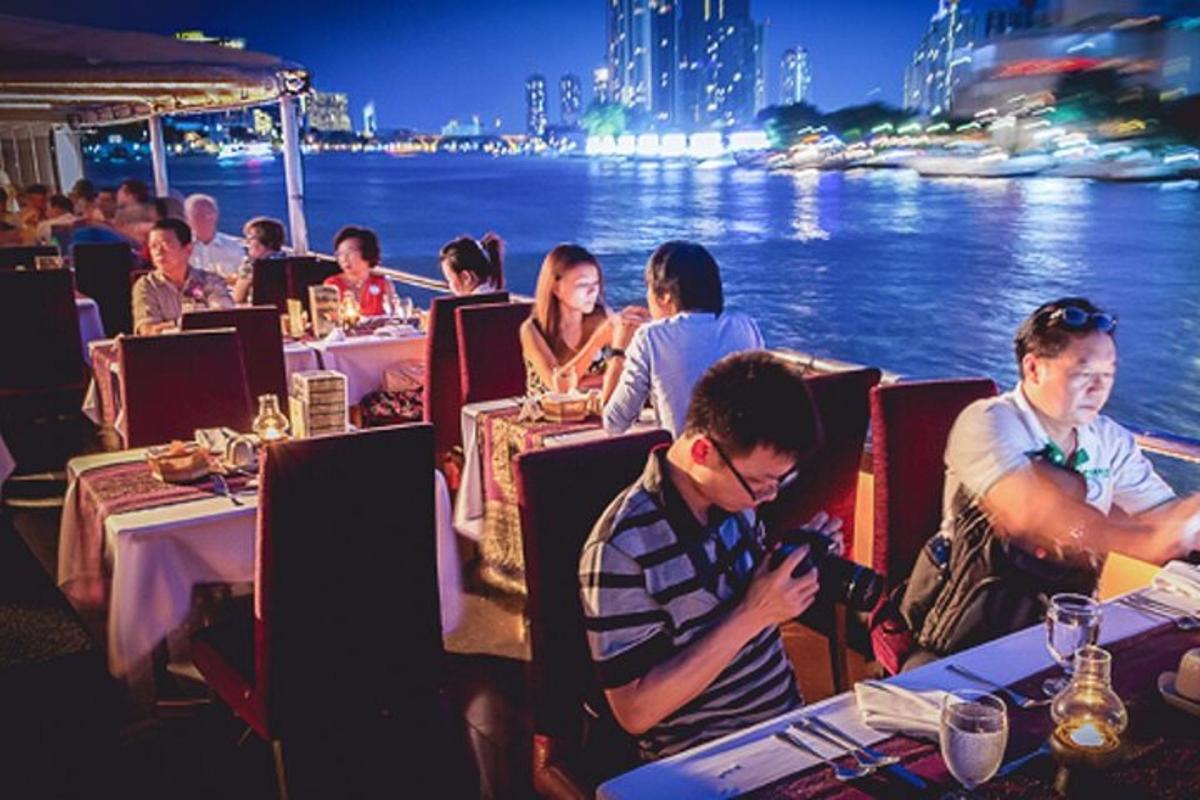 un gruppo di persone sedute ai tavoli di un ristorante in riva all'acqua