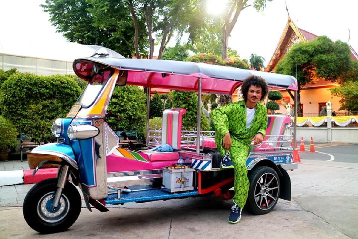 Un hombre está de pie junto a un carrito de golf.