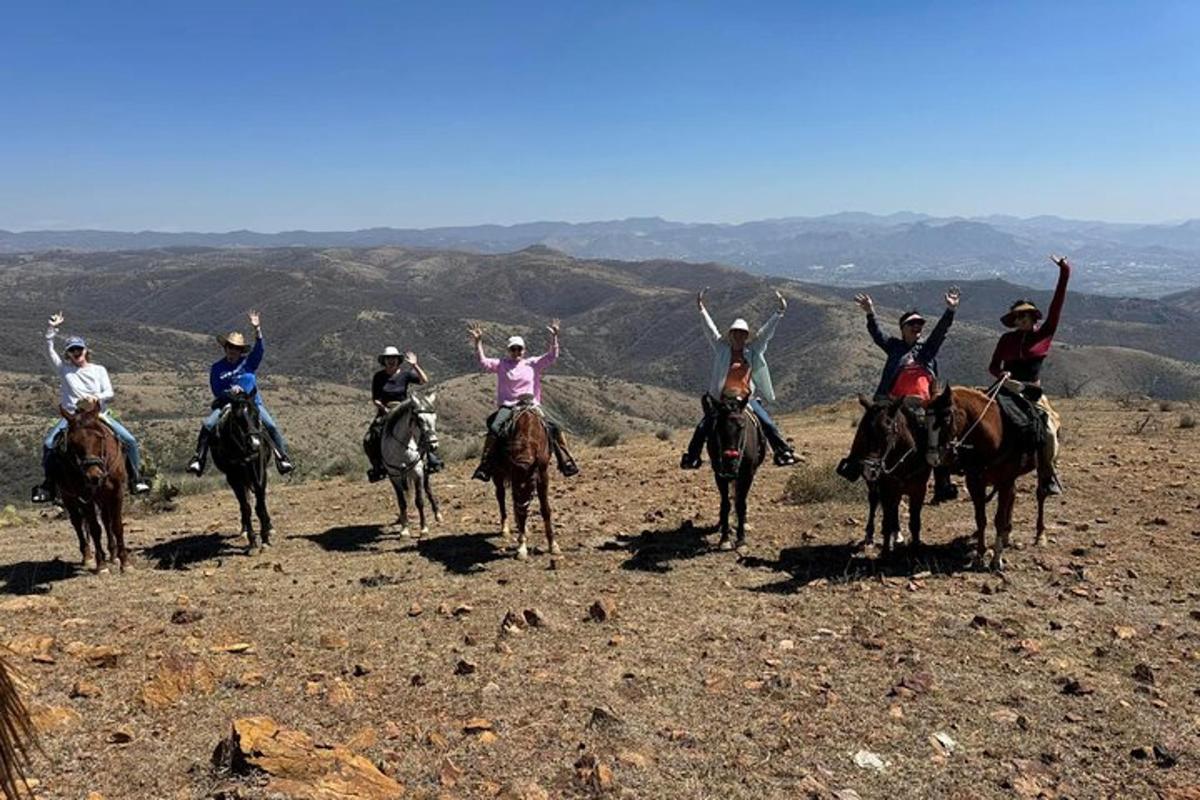 a group of people riding horses on a mountain