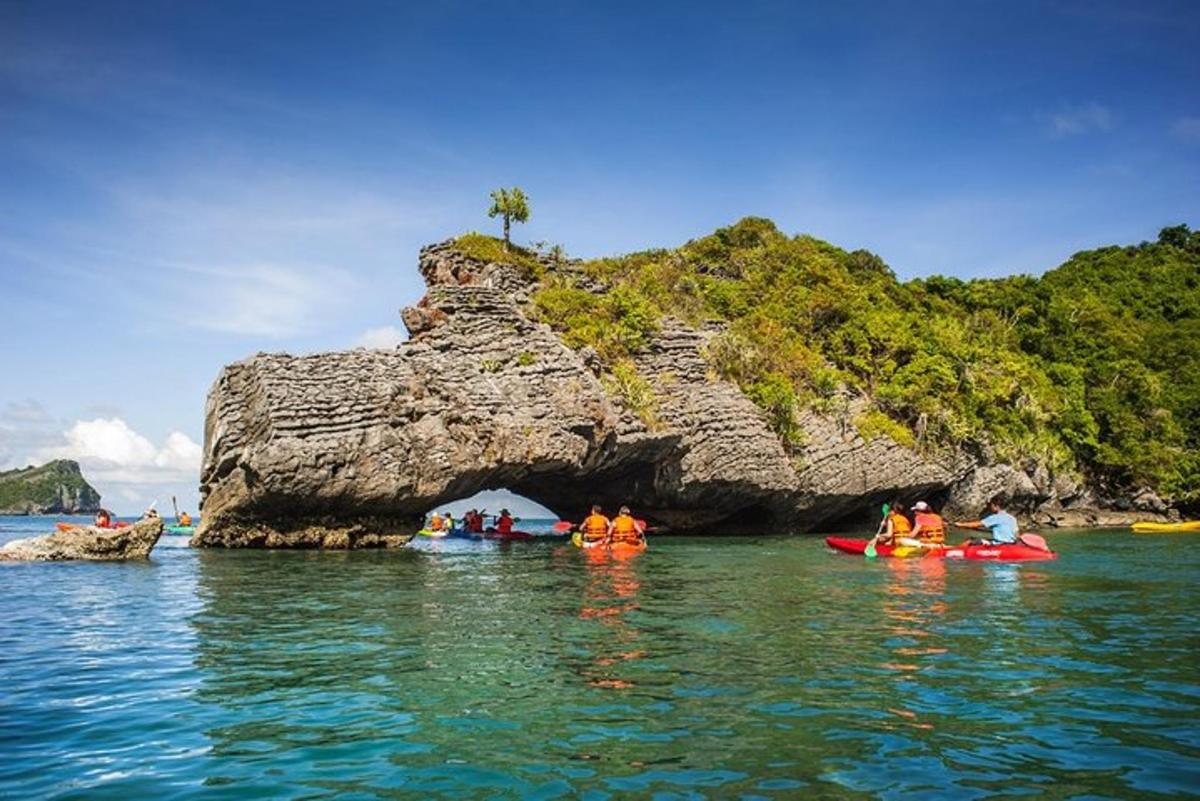 un gruppo di persone in kayak di fronte a una formazione rocciosa