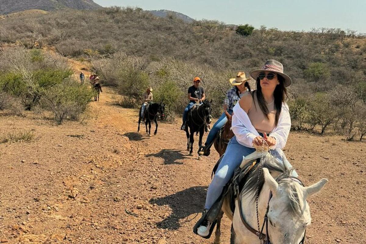 a woman riding on the back of a horse in the desert