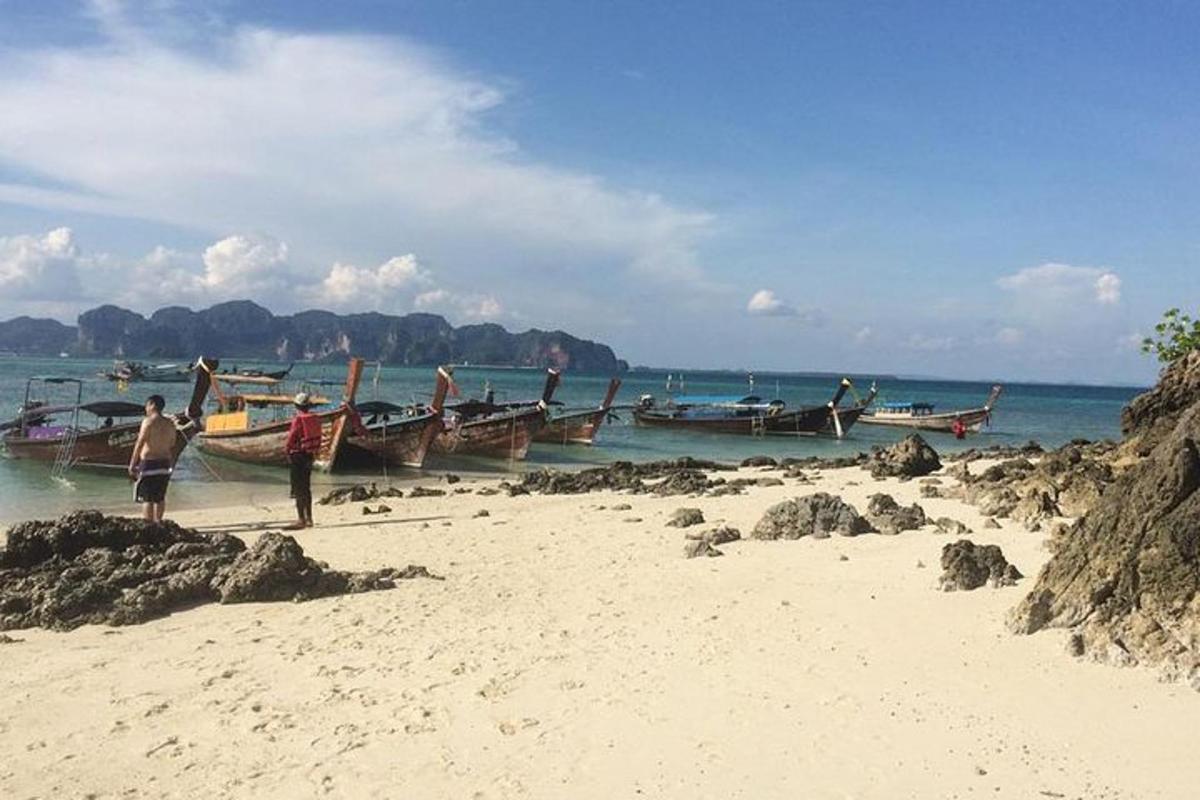 eine Gruppe von Menschen steht mit Booten an einem Strand