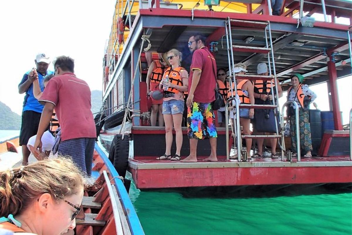 un gruppo di persone in piedi sul lato di una barca