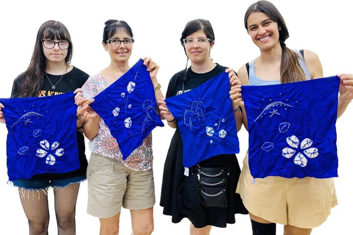 un gruppo di quattro donne che tengono in mano asciugamani blu