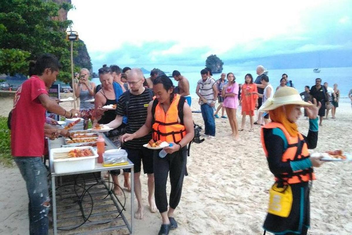 một nhóm người đang ăn đồ ăn trên bãi biển
